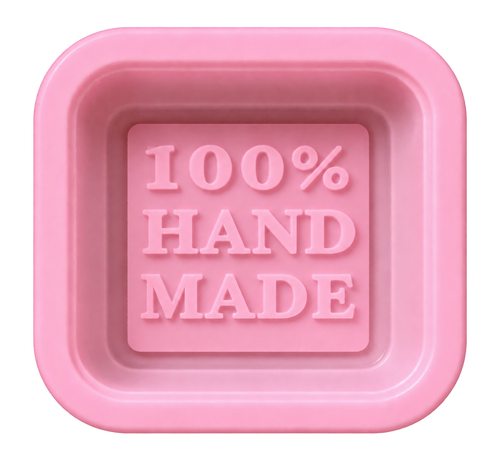A pink square soap bar with rounded corners, featuring the embossed text '100% HAND MADE' in the center, isolated on a white background.